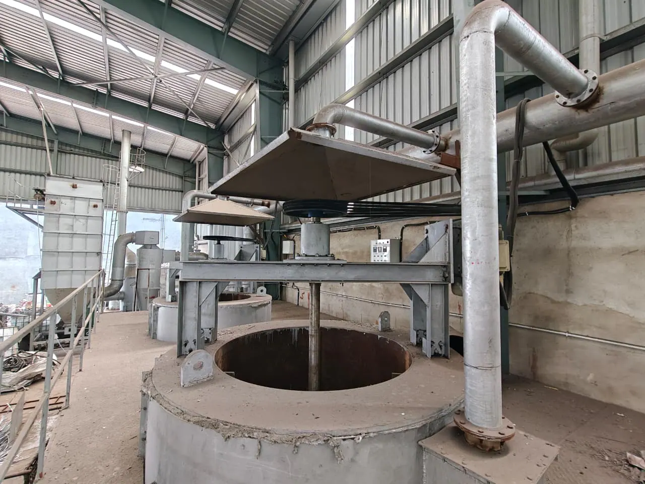Open cylindrical process vessel with a central agitator, overhead belt drive, extraction hood and connected ducting