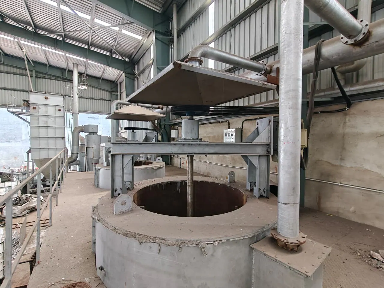 Alternate view of an open agitated process vessel beneath a square extraction hood and belt drive