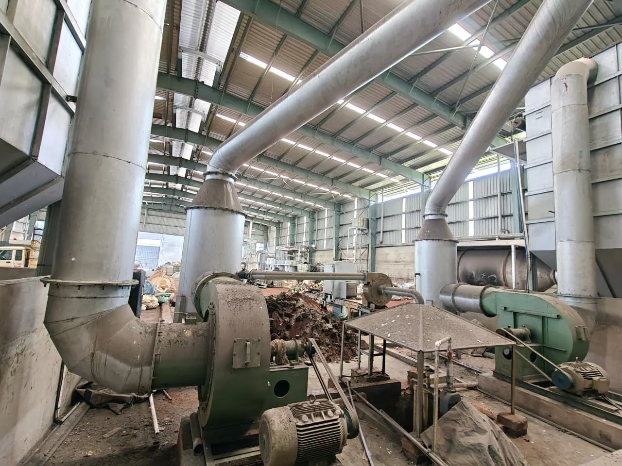 Two induced-draft fan housings installed beside large interconnected industrial ducts