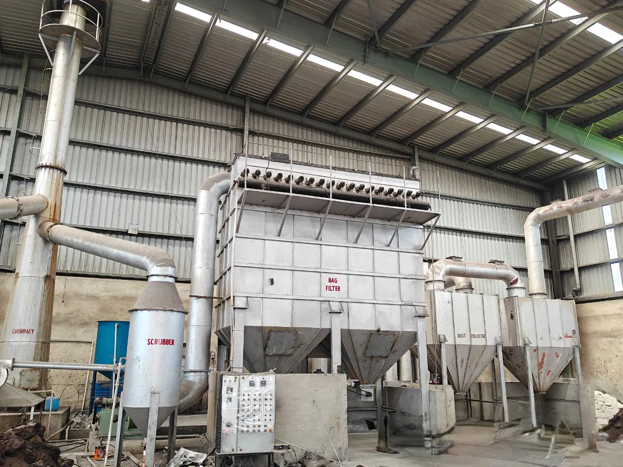 Integrated pollution-control installation with bag-filter housing, wet scrubber, connecting ducts and industrial stack