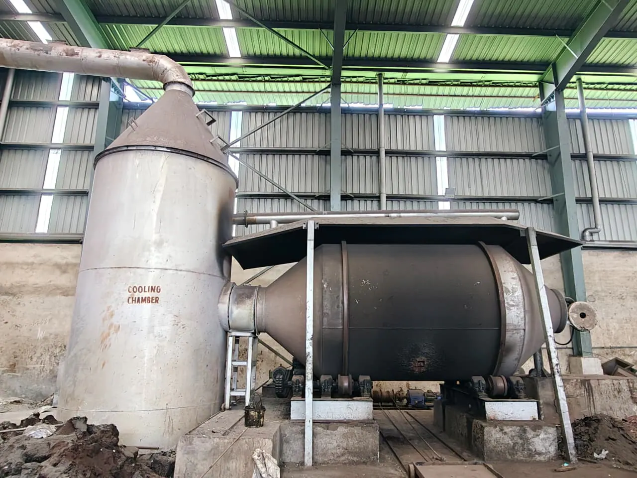 Rotary furnace installation connected by industrial ducting to a cooling chamber