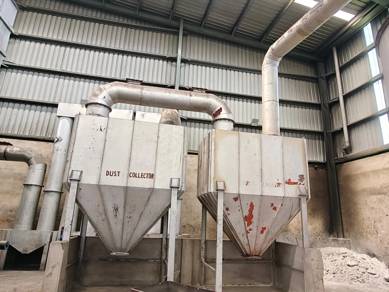 Two fabricated hopper-bottom dust-collector units installed side by side with connecting ductwork