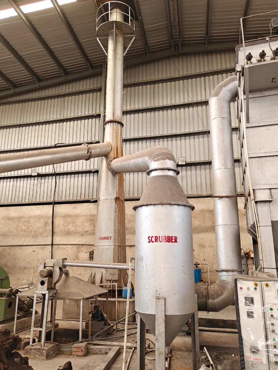 Portrait view of a wet scrubber, industrial chimney and induced-draft fan connected by pipework
